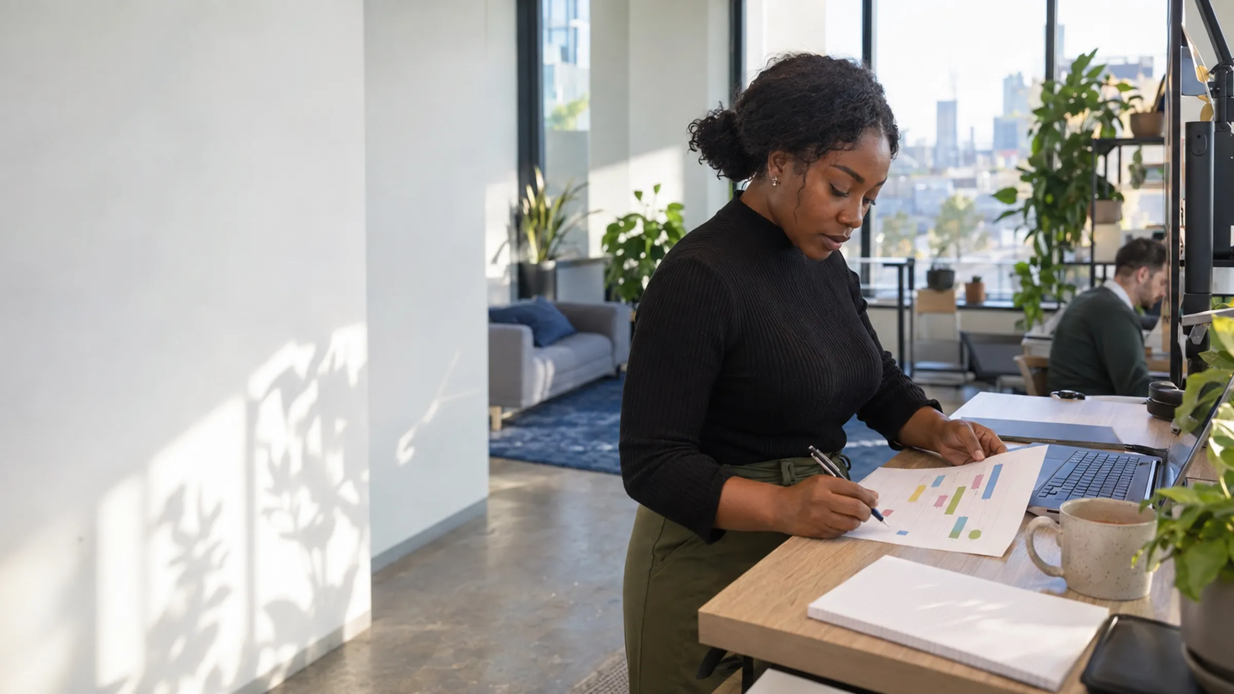 A team lead reviewing a printed product roadmap at a standing desk in a bright software office